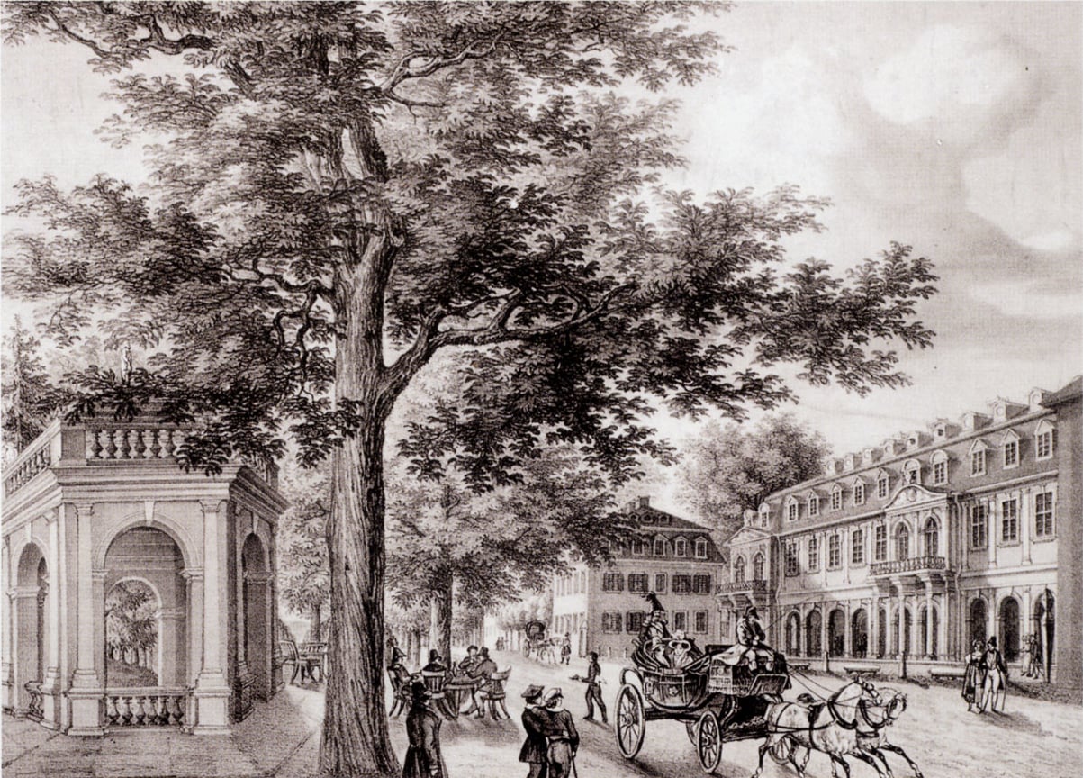Litografia de 1833 da estação de águas de Wilhelmsbad, perto de Hanau: à esquerda, um pavilhão de arcos sob uma grande árvore; à direita, o edifício de arcadas, uma carruagem puxada por cavalos e pessoas passeando.